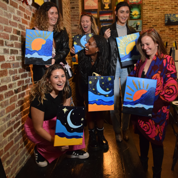 Group of friends showing their paintings