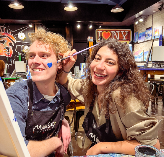 Couples painting at a studio